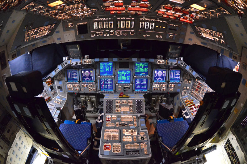 astronauts in space shuttle cockpit